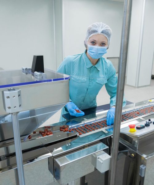 trabalhador-de-mulher-de-industria-de-farmacia-em-roupas-de-protecao-operacional-producao-de-comprimidos-em-condicoes-de-trabalho-esteril-min